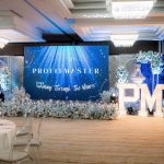 Decorated event stage with "PROFITMASTER" screen and large illuminated "PM11" letters.