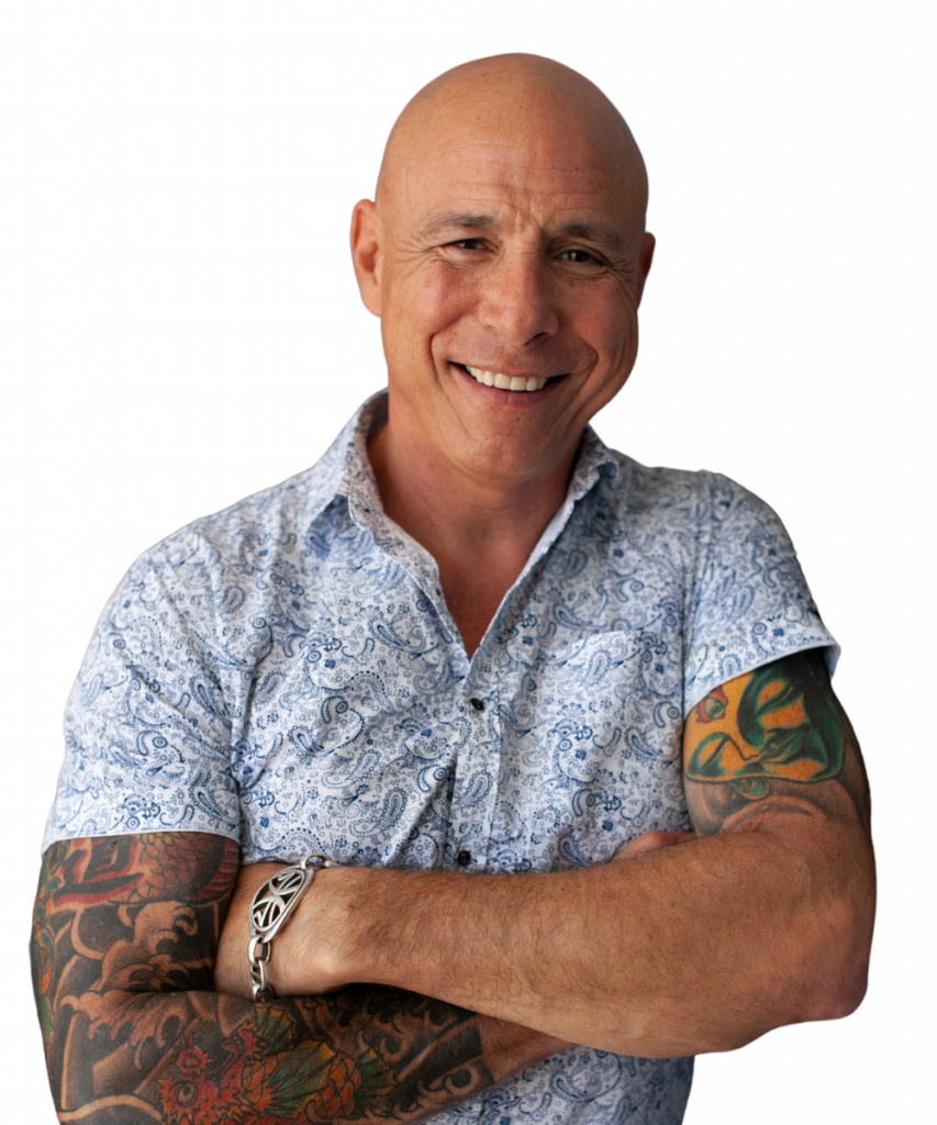 Bald man with tattooed arms, smiling in a patterned shirt at the 2025 Leaders Conference.