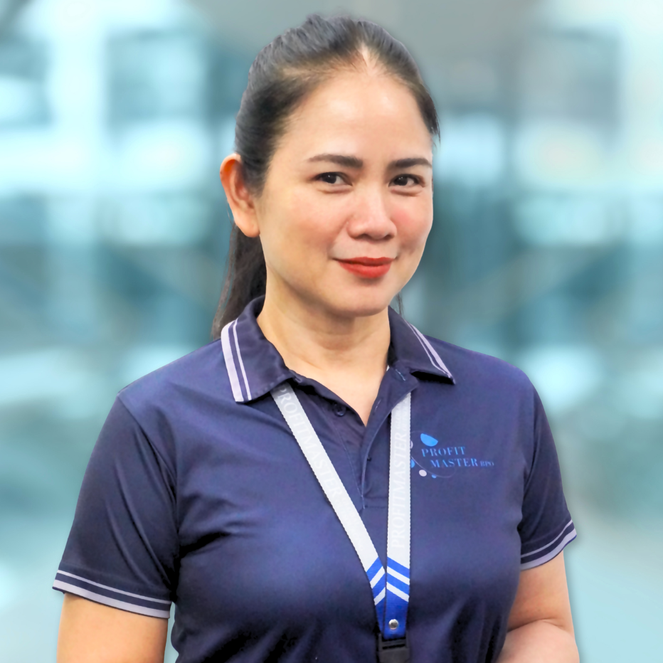 Woman with a ponytail wearing a navy collared shirt and lanyard, standing indoors.